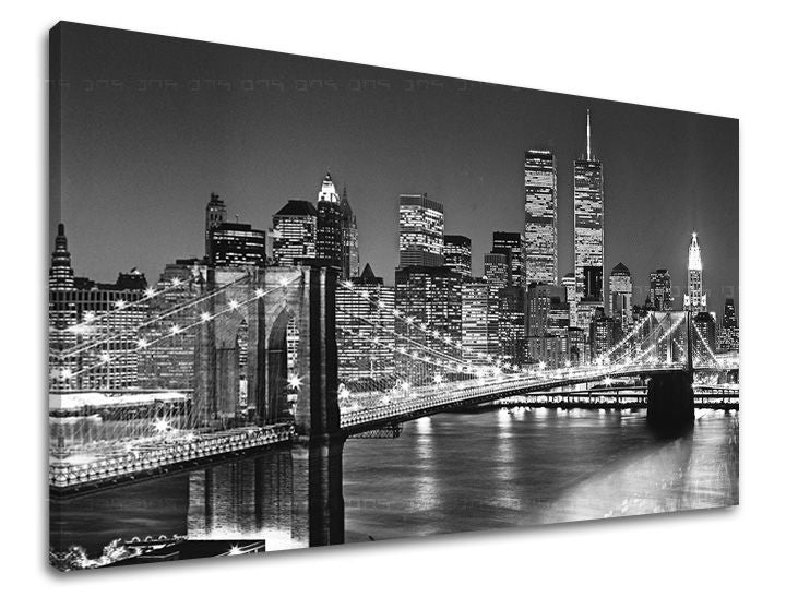 Černobílý tisk na plátně zachycuje noční panorama New Yorku s osvětleným Brooklynským mostem a mrakodrapy, včetně Dvojčat Světového obchodního centra, s viditelným dřevěným rámem Papilora.