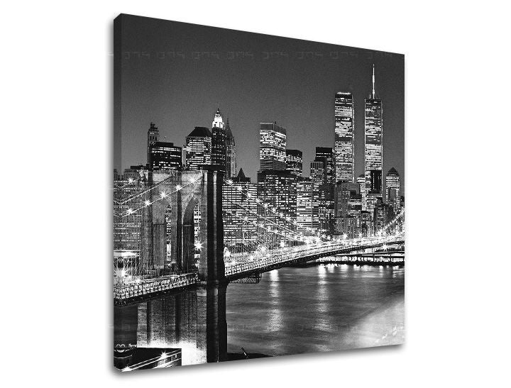 Černobílý tisk na plátně zachycuje noční panorama New Yorku s Brooklynským mostem a osvětlenými mrakodrapy, viditelný je dřevěný rám Papilora.