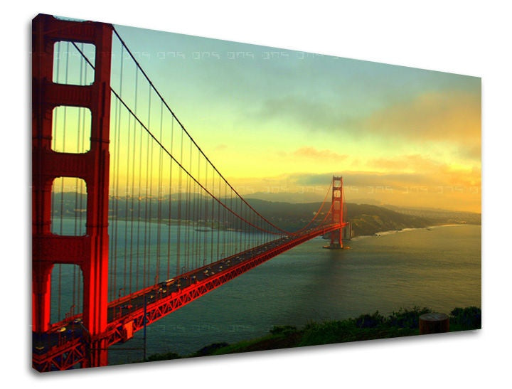Na plátně je zobrazen ikonický most Golden Gate v červených a zlatých tónech při západu slunce, s viditelným dřevěným rámem Papilora.