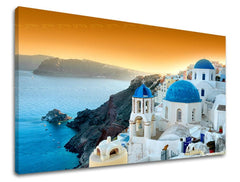 Nádherný pohled na bílé domy s modrými kupolemi na Santorini s mořem a oranžovou oblohou, zobrazený na plátně s viditelným dřevěným rámem Papilora.