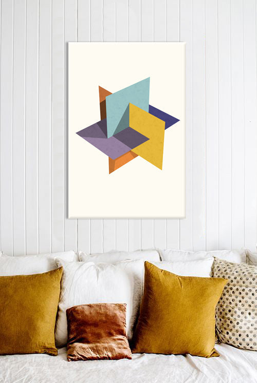 Abstraktní obraz s geometrickými tvary v modré, žluté a fialové barvě visící v moderním interiéru nad dřevěnou konzolí s vázou a svíčkou Papilora.