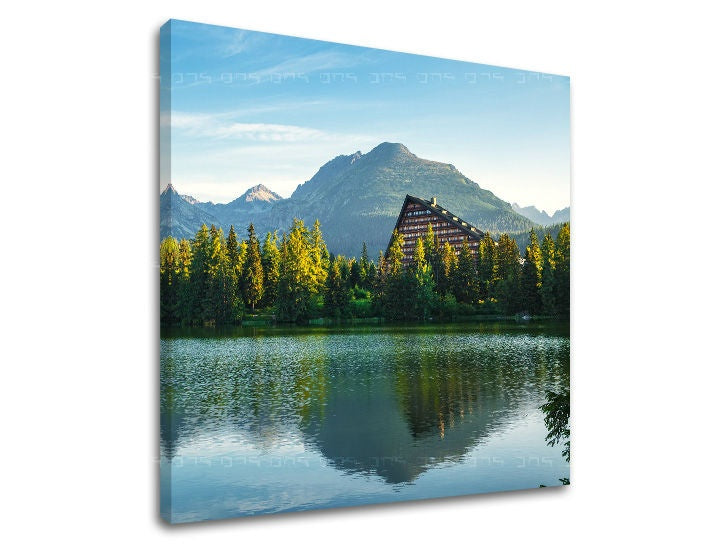 Obraz na plátně zobrazuje Štrbské pleso s hotelem a horami v pozadí, v modro-zelených tónech Papilora.