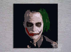 Ručně malované plátno s vyobrazením Jokera s výrazným zelenými vlasy a červenými rty na tmavém pozadí, s viditelným dřevěným rámem, Papilora.