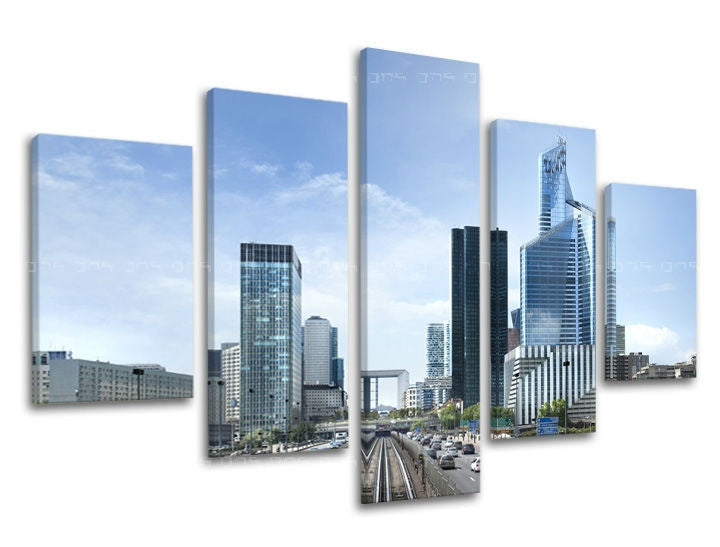 Na plátně je zachyceno panoráma moderního města s mrakodrapy a dálnicí pod jasně modrou oblohou Papilora.