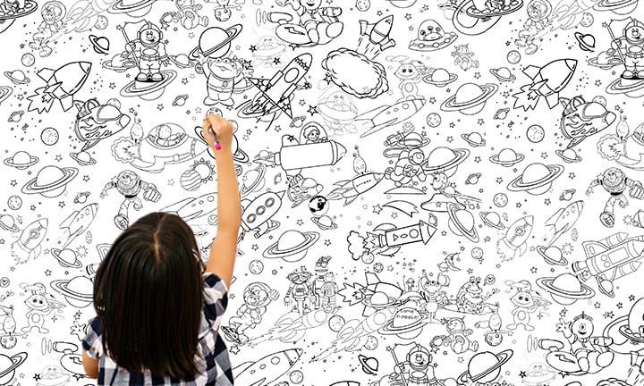 V moderním interiéru nad dřevěnou konzolí s vázou a svíčkou visí šablona pro malování podle čísel s detailním vyobrazením vesmírných lodí a planet, čekající na oživení barvami Papilora.