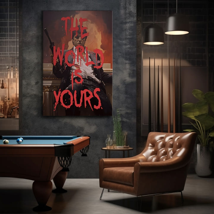 Obraz Tonyho Montany s puškou a nápisem „THE WORLD IS YOURS“ v červené barvě na pozadí ohně, visící v moderním interiéru nad dřevěnou konzolí s vázou a svíčkou Papilora.