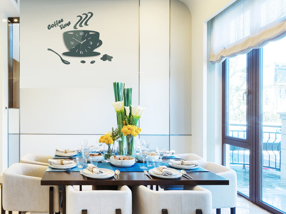 Moderní nástěnné hodiny ve tvaru šálku kávy s nápisem 'coffee time' a zrnky kávy, v tmavě zelené barvě, visí v elegantním interiéru nad dřevěnou konzolí s vázou a svíčkou Papilora.
