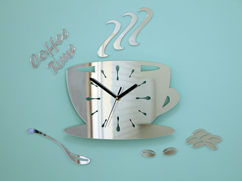 Nástěnné hodiny ve tvaru šálku kávy s nápisem 'Coffee Time' a zrnky kávy, v lesklém stříbrném provedení, visí v moderním stylovém interiéru nad dřevěnou konzolí s vázou a svíčkou Papilora.