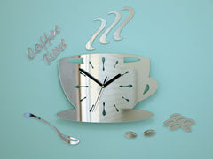 Nástěnné hodiny ve tvaru šálku kávy s nápisem 'Coffee Time' a zrnky kávy, v lesklém stříbrném provedení, visí v moderním stylovém interiéru nad dřevěnou konzolí s vázou a svíčkou Papilora.