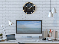 Moderní nástěnné hodiny s minimalistickým designem a motivem krajiny, zavěšené nad dřevěnou konzolí s vázou a svíčkou, Papilora.