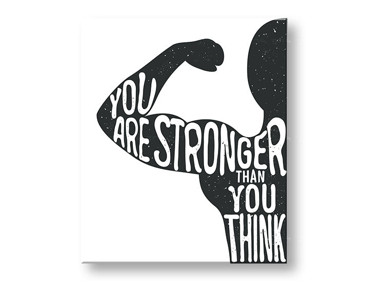 Obraz s motivačním citátem „YOU ARE STRONGER THAN YOU THINK“ v černobílém provedení, zavěšený v moderním interiéru nad dřevěnou konzolí s vázou a svíčkou Papilora.