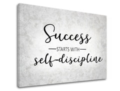 Plátno s černým nápisem „Success starts with self-discipline“ na světle šedém pozadí s texturou, viditelný dřevěný rám Papilora.