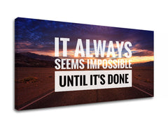 Obraz s motivačním citátem „IT ALWAYS SEEMS IMPOSSIBLE UNTIL IT’S DONE“ na pozadí západu slunce nad pouštní krajinou, s viditelným dřevěným rámem, Papilora.