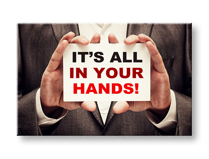 Obraz s motivačním citátem „IT'S ALL IN YOUR HANDS!“ visí v moderním interiéru nad dřevěnou konzolí s vázou a svíčkou Papilora.