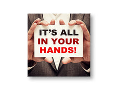 Obraz s motivačním citátem „IT'S ALL IN YOUR HANDS!“ zavěšený v moderním interiéru nad dřevěnou konzolí s vázou a svíčkou Papilora.