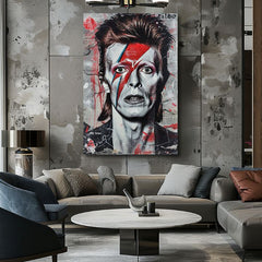 Obraz Davida Bowieho s ikonickým bleskem na tváři visí v moderním interiéru nad dřevěnou konzolí s vázou a svíčkou Papilora.