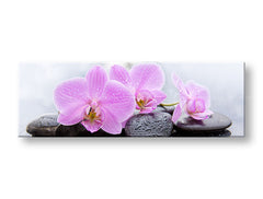 Moderní interiér zdobí obraz s růžovými orchidejemi a černými kameny, umístěný nad dřevěnou konzolí s vázou a svíčkou Papilora.