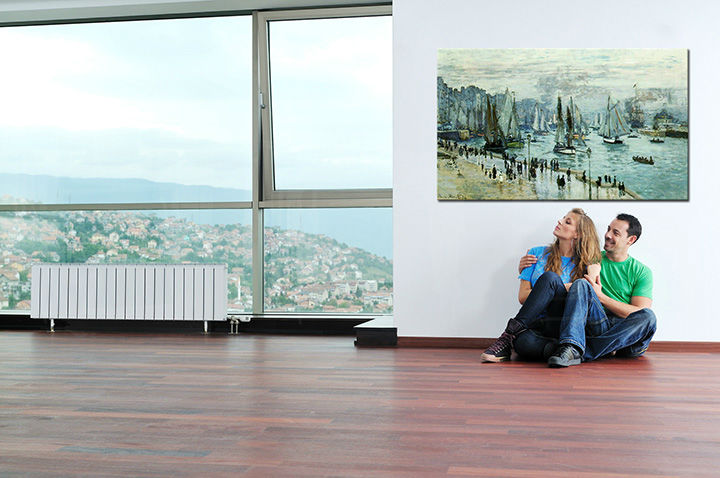 Umělecké dílo s motivem přístavu a lodí visí v moderním interiéru nad dřevěnou konzolí s vázou a svíčkou, což vytváří elegantní atmosféru Papilora.