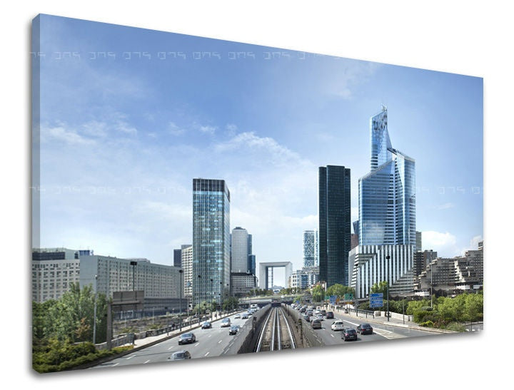 Na plátně je zachyceno panoráma moderního města s mrakodrapy a rušnou dálnicí pod jasně modrou oblohou Papilora.