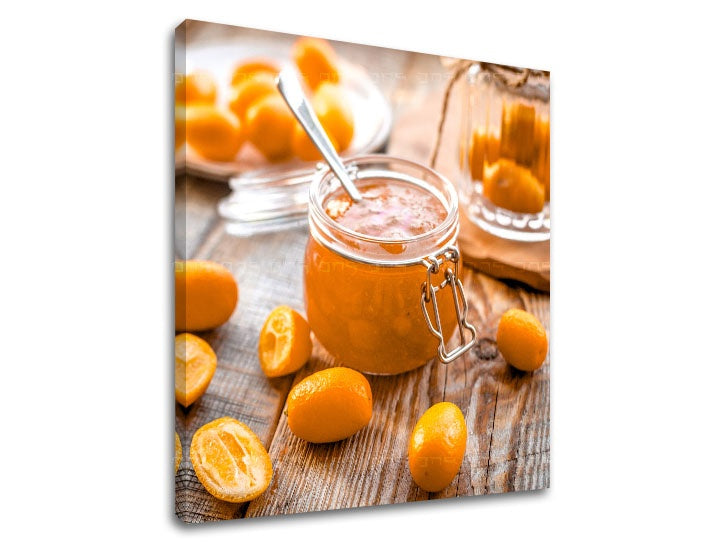 Kompozice zachycuje sklenici džemu z kumquatu a rozložené čerstvé plody na dřevěném pozadí Papilora.