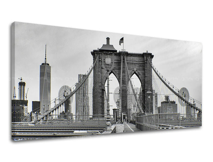 Černobílý tisk Brooklynského mostu s mrakodrapy v pozadí na plátně s viditelným dřevěným rámem Papilora.