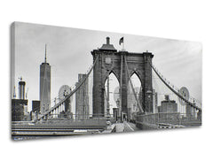 Černobílý tisk Brooklynského mostu s mrakodrapy v pozadí na plátně s viditelným dřevěným rámem Papilora.