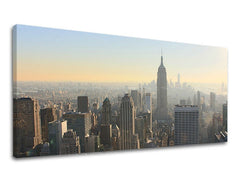 Detailní pohled na panoráma New Yorku s dominantní budovou Empire State Building v ranním oparu, zobrazený na plátně s viditelným dřevěným rámem, Papilora.