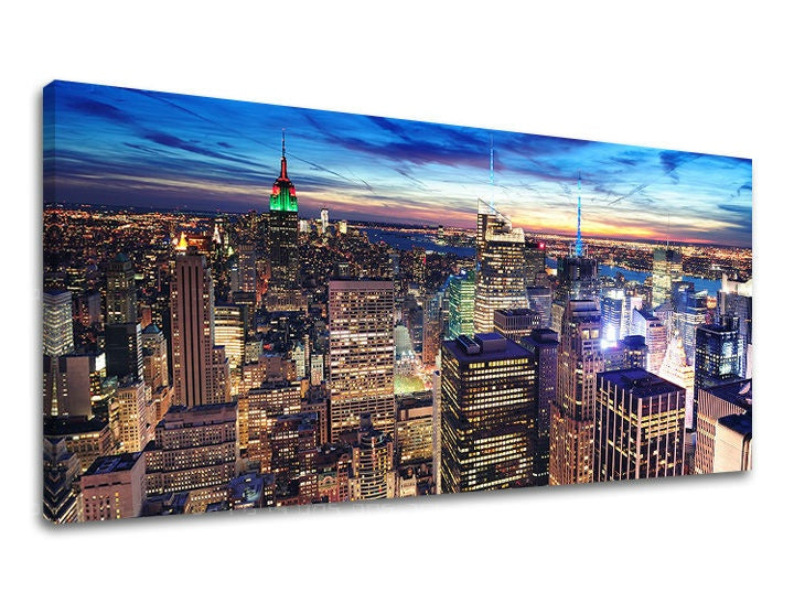 Na plátně je zachyceno noční panorama New Yorku s osvětlenými mrakodrapy a dominantní budovou Empire State Building v červeno-zelených barvách, pod tmavě modrou oblohou Papilora.