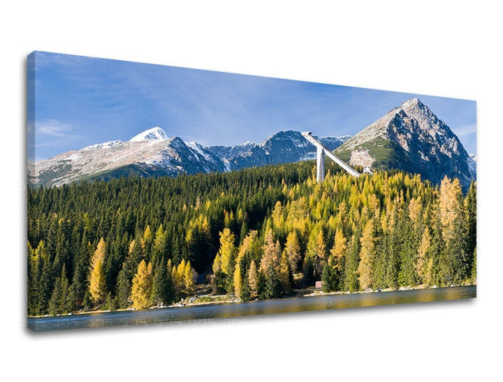 Obraz na plátně zobrazuje Štrbské pleso s podzimními stromy a zasněženými horami pod modrou oblohou Papilora.