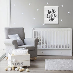 Plátno s nápisem „hello little one“ v černé barvě na bílém pruhovaném pozadí, s viditelným dřevěným rámem, Papilora.