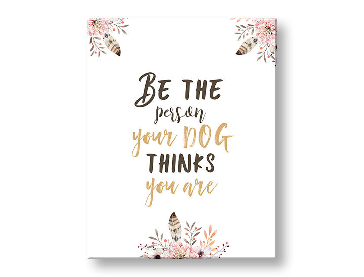 Obraz s citátem „Be the person your dog thinks you are“ a růžovými květinami visící v moderním interiéru nad dřevěnou konzolí s vázou a svíčkou, Papilora.
