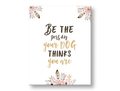 Obraz s citátem „Be the person your dog thinks you are“ a růžovými květinami visící v moderním interiéru nad dřevěnou konzolí s vázou a svíčkou, Papilora.