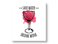 Obraz s motivem sklenice na víno a nápisem „SAVE WATER DRINK WINE“ visí v moderním interiéru nad dřevěnou konzolí s vázou a svíčkou, Papilora.
