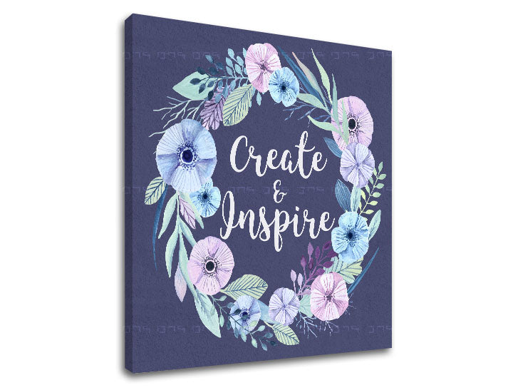 Nástěnná dekorace s květinovým věncem a nápisem „Create & Inspire“ na tmavě modrém pozadí, viditelná na plátně s dřevěným rámem Papilora.