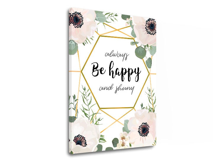 Detailní náhled kompozice ukazuje bílé květy s tmavými středy, zelené lístky a zlaté geometrické linie obklopující nápis „Be happy“, Papilora.