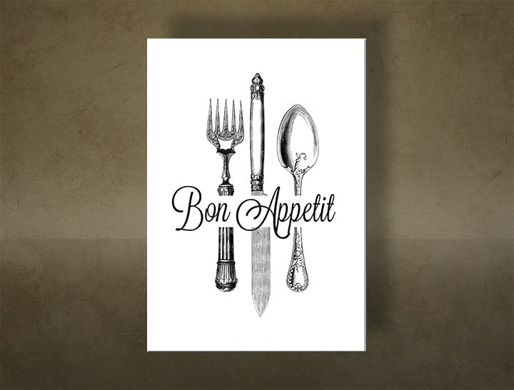 Detailní náhled kompozice zobrazuje elegantní vidličku, nůž a lžíci s ozdobnými rukojeťmi a nápisem „Bon Appetit“ Papilora.