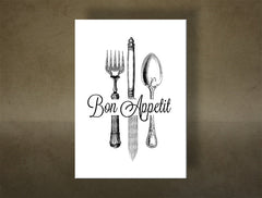 Detailní náhled kompozice zobrazuje elegantní vidličku, nůž a lžíci s ozdobnými rukojeťmi a nápisem „Bon Appetit“ Papilora.
