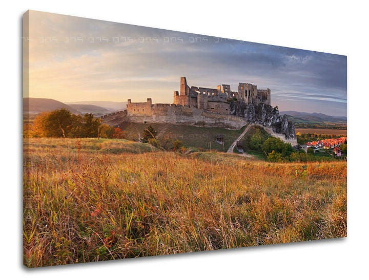 Obraz na plátně zobrazuje majestátní Spišský hrad na kopci s podzimní trávou v popředí, zalitý teplým světlem zapadajícího slunce, Papilora.