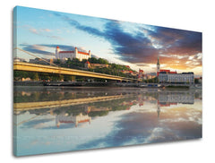 Na plátně je zobrazeno panorama Bratislavy s hradem a mostem přes Dunaj, odrážející se ve vodě pod dramatickým západem slunce, Papilora.