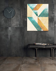 Abstraktní geometrické tvary v tyrkysové a okrové barvě visící v moderním interiéru nad dřevěnou konzolí s vázou a svíčkou Papilora.