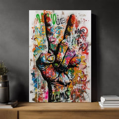Moderní interiér zdobí obraz s rukou ukazující symbol míru, s výraznými graffiti prvky v mnoha barvách, umístěný nad dřevěnou konzolí s vázou a svíčkou Papilora.