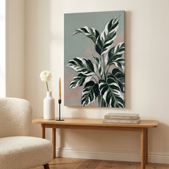 Moderní obraz s motivem tropických listů zavěšený nad elegantní dřevěnou konzolou v interiéru obývacího pokoje s vázou a svíčkou.