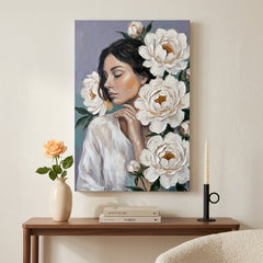 Obraz ženy s bílými květy v moderním obývacím pokoji, zavěšený nad elegantní dřevěnou konzolou s dekoracemi.