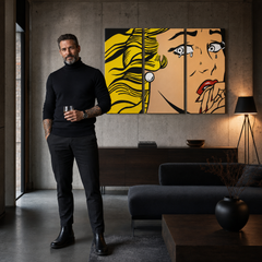 Obraz plačící ženy v pop-art stylu, s dominujícími žlutými a béžovými tóny, visí v moderním interiéru nad dřevěnou konzolí s vázou a svíčkou Papilora.