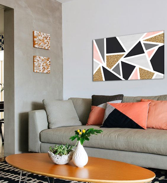 Moderní geometrický obraz v černé, šedé, růžové a zlaté barvě visící v elegantním interiéru nad dřevěnou konzolí s vázou a svíčkou, Papilora.