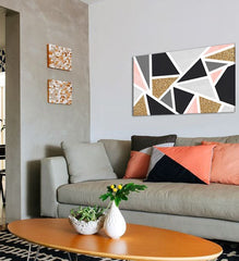 Moderní geometrický obraz v černé, šedé, růžové a zlaté barvě visící v elegantním interiéru nad dřevěnou konzolí s vázou a svíčkou, Papilora.