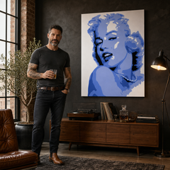 Obraz s modrým portrétem Marilyn Monroe visí v moderním interiéru nad dřevěnou konzolí s vázou a svíčkou, Papilora.