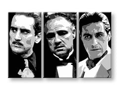 Tři černobílé portréty mužů z filmu Kmotr visí v moderním interiéru nad dřevěnou konzolí s vázou a svíčkou Papilora.